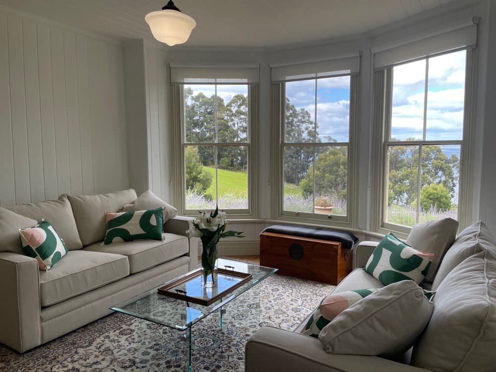 Bright living room with panoramic bay windows — The Cottage at Flowerpot, Southern Tasmania