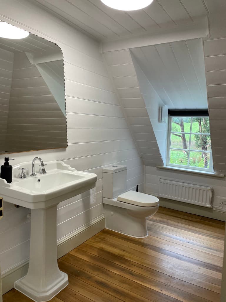 Upstairs heritage bathroom with pedestal basin and timber floors — The Cottage at Flowerpot, Southern Tasmania