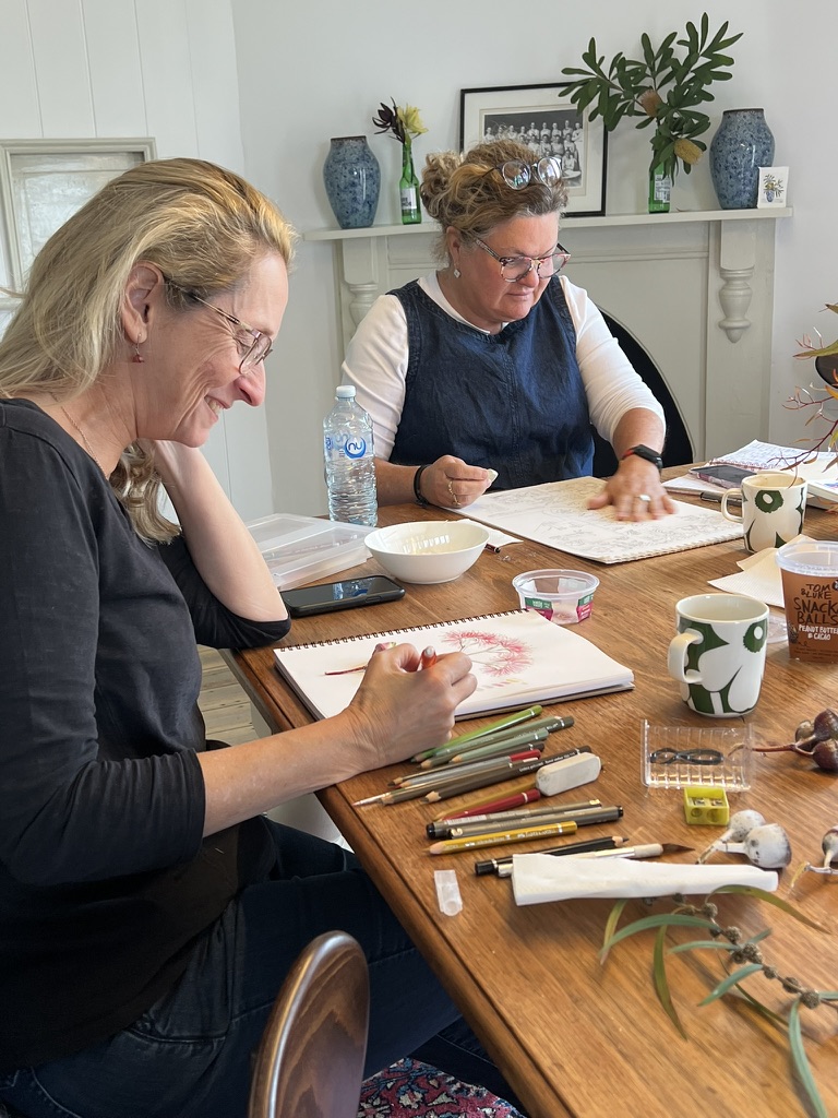 Two artists drawing botanical illustrations together